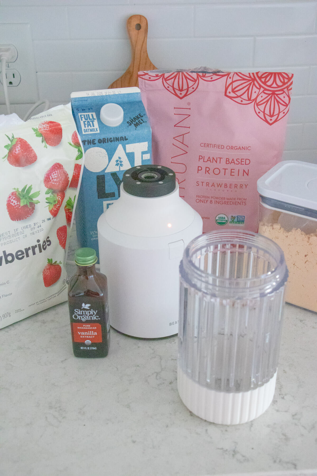 Blender with ingredients for a strawberry protein smoothie recipe and a blender