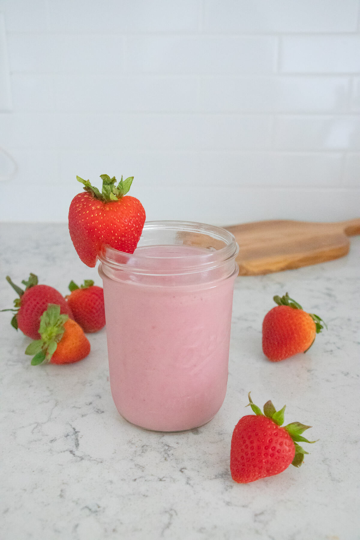 Strawberry smoothie with strawberries in the background