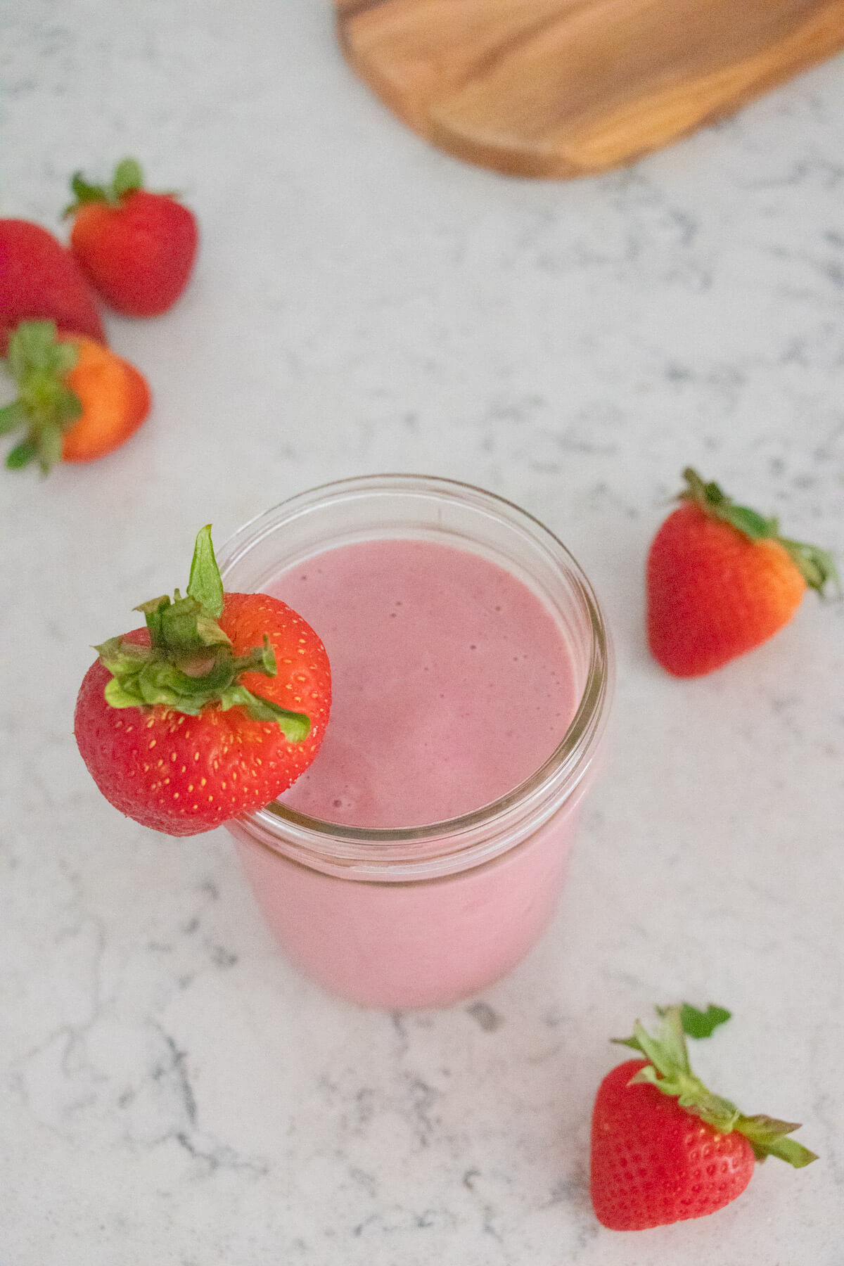 Strawberry smoothie with strawberries in the background